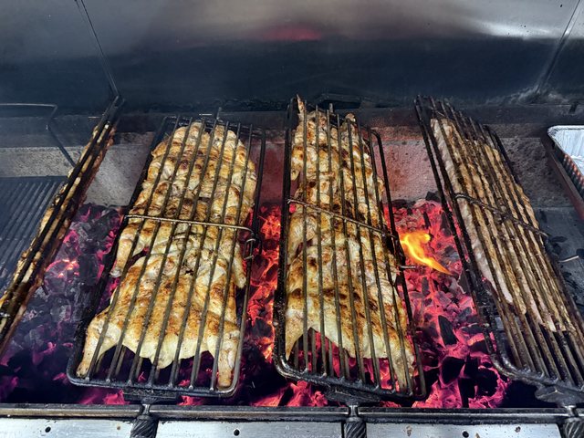 Chickens grilling over live charcoal